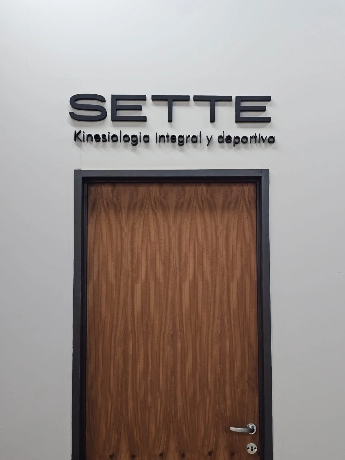 Letras negras de Sette sobre una puerta de madera